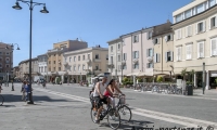 Famiglia in bicicletta in Piazza Tre Martiri, Rimini